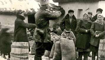 Soliders confiscate grain from peasants in Novokrane, Ukraine in 1932. (Photo courtesy of the University of Alberta)