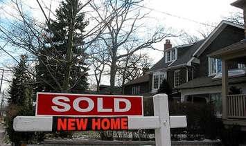 A home with sold sign. File photo courtesy of © Can Stock Photo / Elenathewise