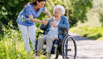 Caregiver and senior woman in wheelchair (Image courtesy of Halfpoint / iStock / Getty Images Plus via Getty Images)