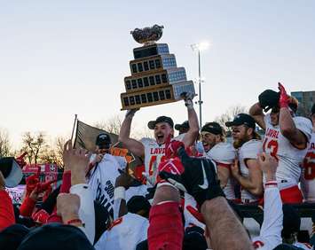 Laval Rouge et Or football players lift the Vanier Cup after winning the university football championship in London, November 26, 2022. Photo from Tourism London via Facebook. 